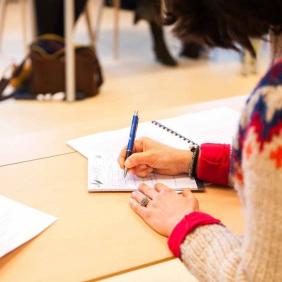 Student writing on a notepad