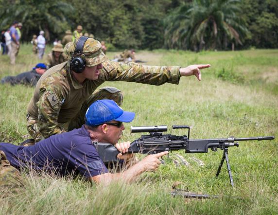 Australian Army soldier Steve Brien (kneeling) from Rifle Company Butterworth rotation 116 briefs Sergeant Rob Stratton from the NSW Police Force during an F89 Minimi range shoot at Gurun field firing range in Malaysia on 11 January 2017.