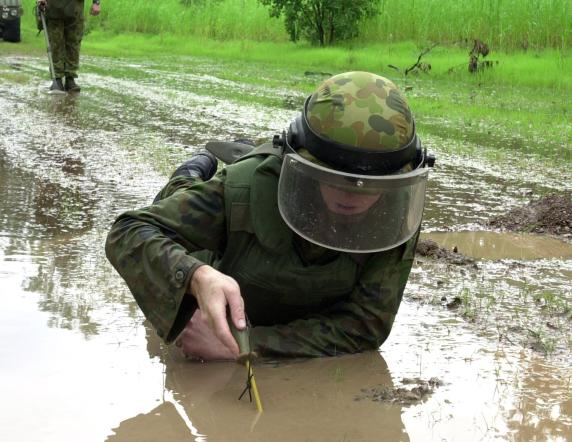 THE ARMY'S NEW LAND MINE CLEARING VEHICLE GIVES DEMINING ENGINEERS MORE ACCURACY IN LOCATING ANTI-TANK MINES, BUT OLD FASHIONED SOLDIERING IS STILL REQUIRED TO REMOVE THE DANGEROUS MINES. SAPPER PAUL TEWKESBURY, FROM THE ARMY'S 1ST COMBAT ENGINEER REGIMENT, PART OF THE 1ST BRIGADE AT ROBERTSON BARRACKS, KEEPS A SHARP EYE OUT WHILE SAPPER LUKAS PARKINSON SEARCHES FOR SMALLER MINES.