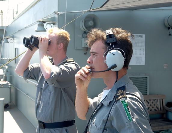 Leading Seaman Boatswain's Mate (LSBM) Matthew Jenkins keeps a lookout for inbound aircraft.