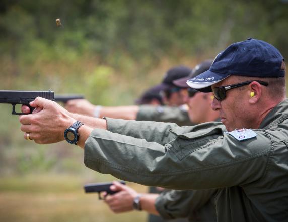 Commander Air Combat Group Air Commodore Steven Roberton, AM, fires a 9mm Browning pistol at the Tindal firing range during his visit to No 75 Squadron.