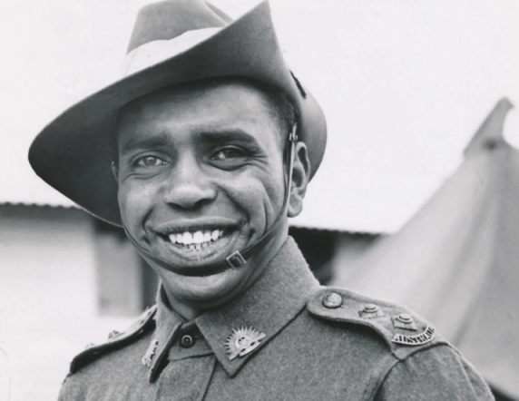 Captain Reginald Saunders, a smiling Aboriginal man, in his Australian Army uniform (black and white photo).