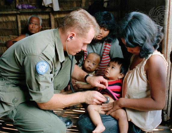 A UN Peacekeeping medic checks a local baby.